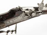 un vieux pistolet muni d'une crosse métallique, sur fond blanc
