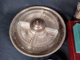 a silver plate with a silver lid next to a book