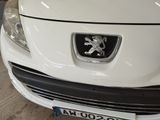 a white car with a lion emblem on the front of it