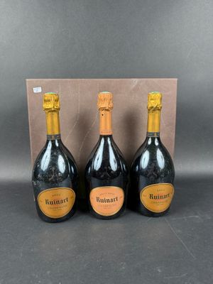 three bottles of champagne in front of a cardboard box
