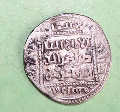 a close up of a silver coin on a green surface