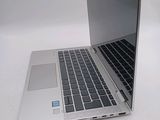 a silver laptop with a black keyboard on a white surface