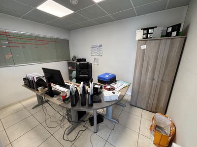 a desk with two computers and a printer on it