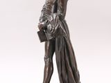 bronze statue of a man holding a basket of flowers on a wooden base