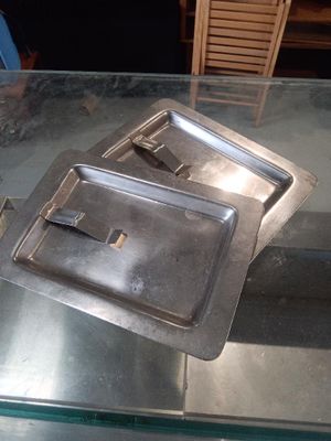 two trays of food sitting on a glass table