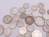 a pile of silver coins on a white surface