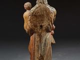 an old statue of a man holding a baby in his arms