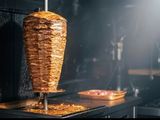 un kebab en train de cuire sur une brochette dans une cuisine
