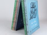 trois livres sont empilés sur une surface blanche