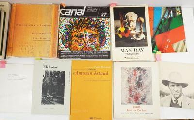 several books are stacked on a white table in front of a wall