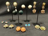 a group of earrings and brooches sitting on a black surface