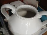 a white tea pot sitting on top of a plastic container