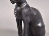 statue of an egyptian cat sitting on a white surface