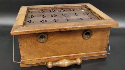 Chaufferette en noyer mouluré, plaque métallique ajourée