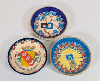 trois assiettes à motifs différents posées sur une surface blanche