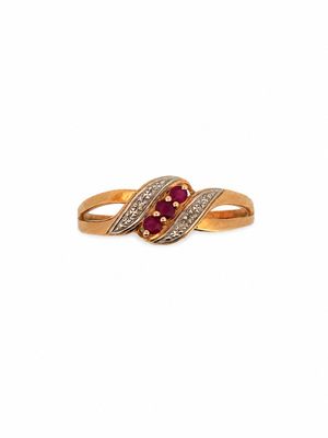 a close up of a gold ring with a ruby stone and diamonds