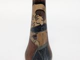 a small vase with a picture of a man on it