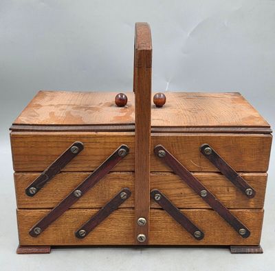 une image représentant une boîte en bois munie de poignées en cuir, sur fond blanc