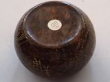 a wooden bowl with writing on it sitting on a table