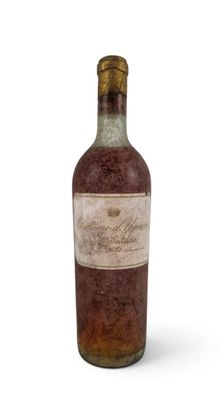 an old bottle of wine sitting on top of a white surface