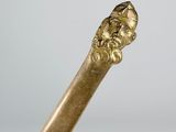 a gold stick with a head of a man on it