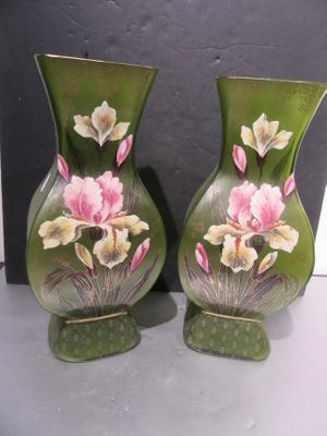 deux vases avec des fleurs peintes dessus, posés sur une table