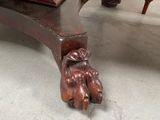 a wooden table with a foot that has a hand on it