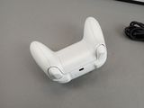 a white wii controller sitting on a table next to a charger