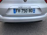 the rear end of a silver car parked on the side of the road