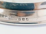 a close up of a silver plate on a white surface