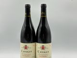 deux bouteilles de vin rouge posées l'une à côté de l'autre sur une table