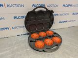 four orange balls in a black case on a table