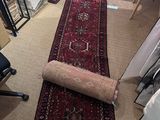rug laying on the floor in a room with a chair and a desk