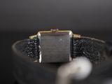 a watch that is sitting on top of a black strap