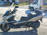 a silver and black scooter parked on the side of the road