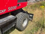 a red tractor that is parked on the side of the road