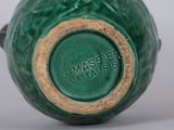 a close up of a green vase on a table