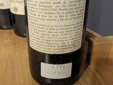 several bottles of wine are lined up on a wooden table