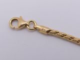 a gold chain that has a gold scissors on it