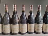 six bottles of wine are lined up in a row on a table