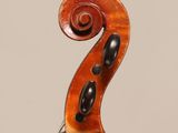 a close up of the back of a violin with a fiddle in the foreground