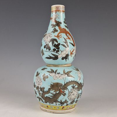 un vase bleu orné d'un dragon, posé sur une table