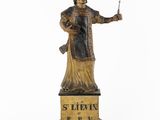 an old statue of a man holding a knife and fork