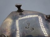 a silver tea pot with a decorative design on it