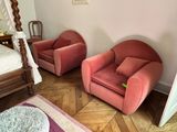 two pink chairs in the corner of a room
