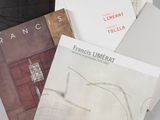 trois livres sont posés sur une table recouverte d'une nappe blanche