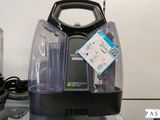 un aspirateur noir et argenté posé sur une table en verre