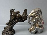 une figurine en argent représentant un éléphant et un éléphant avec un oiseau sur la tête
