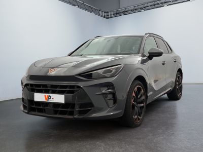 La voiture grise est garée dans une grande pièce au sol noir.