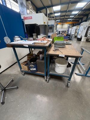 un établi au milieu d'une usine, sur lequel sont posés de nombreux outils